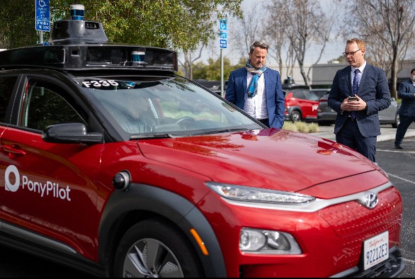 The minister for foreign affairs and foreign trade Xavier Bettel inspects a Pony.ai car during a business trip to California.