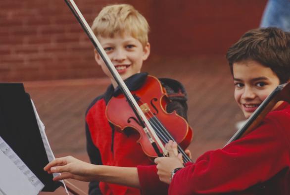 Two boys playing the violin.