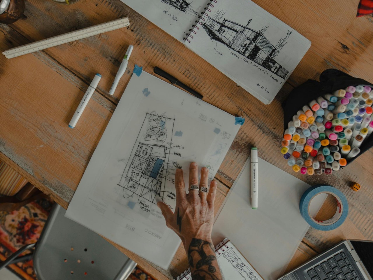 Main dessinant sur un plan d'architecture