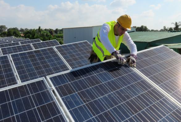 Technicien en train d'installer des panneaux solaires.