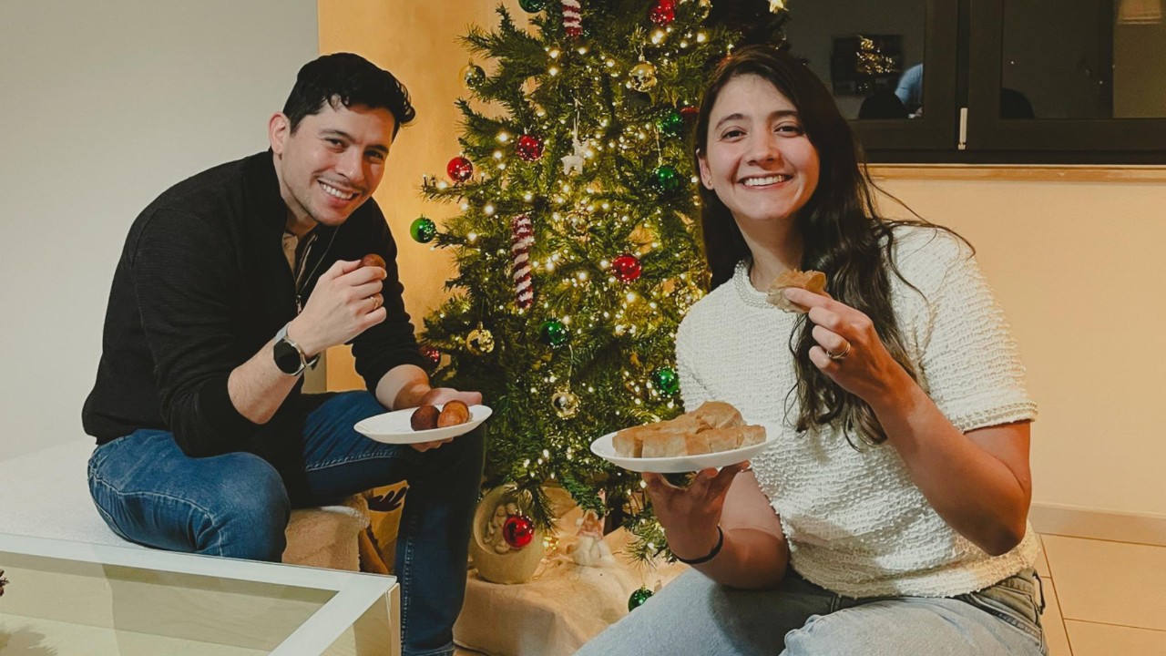 Alexandra et Alejandro sont assis devant leur sapin de Noël et présentant des plats colombiens.