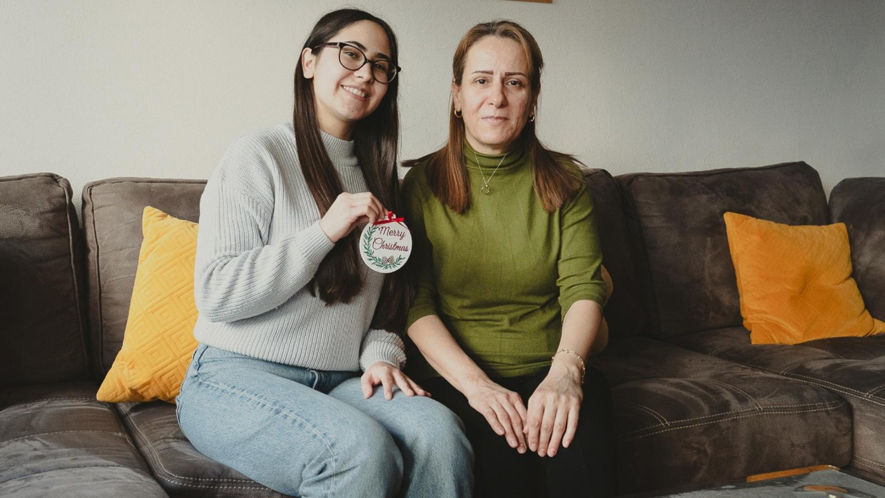 Yousra et Leen sur leur canapé tenant  une boule de Noël.